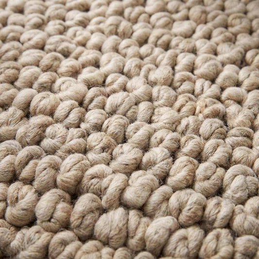 Chunky knit area rug in thick neutral beige with plush handmade texture for cozy living room decor
