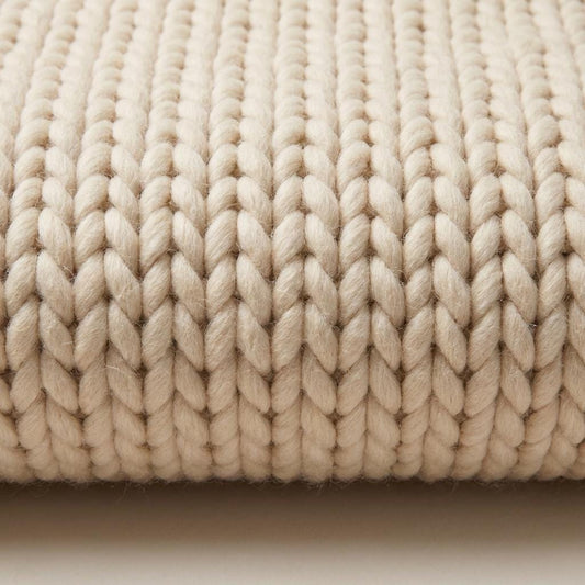 Neutral beige chunky knit wool rug with thick braided texture for cozy Scandinavian minimalist living room decor