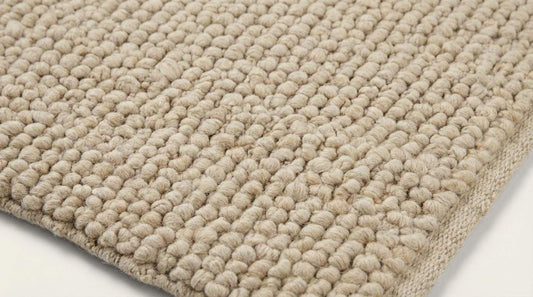 Chunky knit wool rug in cream beige with thick handmade textured loops for cozy home decor