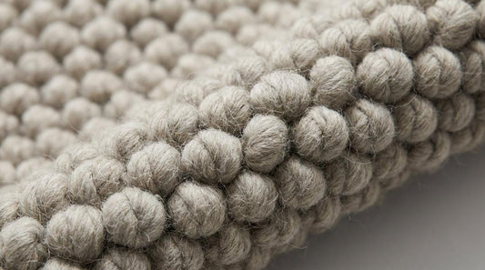 Chunky loop rug in neutral ivory with thick, plush texture for cozy modern living rooms