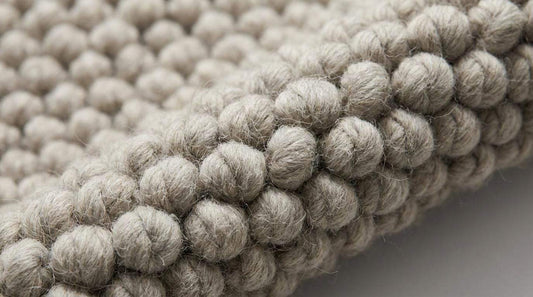 Chunky loop rug in neutral ivory with thick, plush texture for cozy modern living rooms
