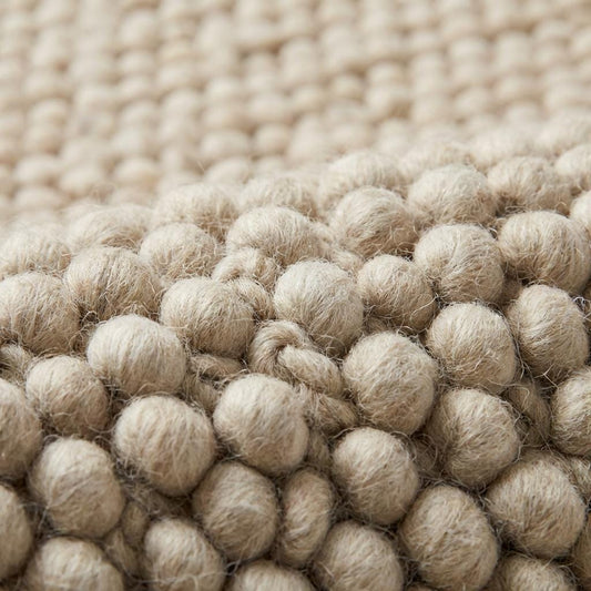 Chunky loop textured cream area rug with plush, nubby surface in modern organic living room setting