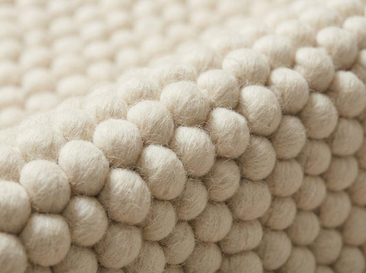 Chunky wool ivory area rug with thick textured oversized loops in Scandinavian neutral living room setting