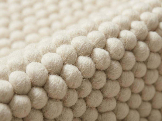 Chunky wool ivory area rug with thick textured oversized loops in Scandinavian neutral living room setting