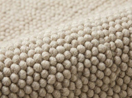 Chunky wool neutral area rug with textured ivory loops for cozy modern interiors