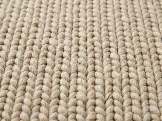 Chunky wool neutral area rug with thick knit texture in a cozy modern living room setting