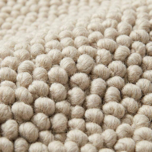 Chunky wool neutral area rug with thick textured cream loops in cozy modern interior