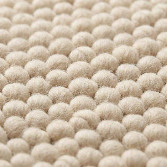Chunky wool rug with handwoven pebble texture in neutral cream, perfect for modern boho and minimalist living room decor