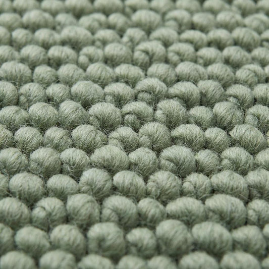 Chunky wool textured area rug in sage green with thick looped texture and cozy cushioned feel