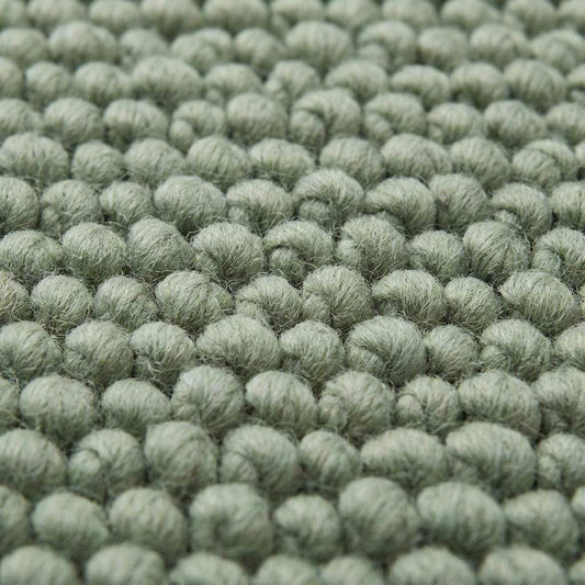 Chunky wool textured area rug in sage green with thick looped texture and cozy cushioned feel