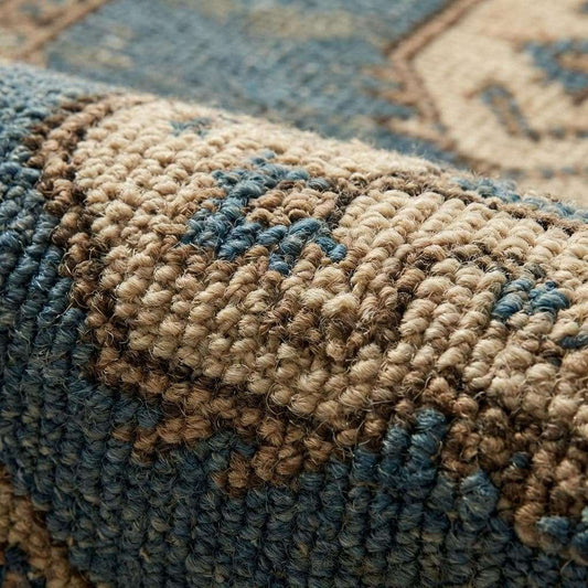 Close-up of hand knotted wool pile showing individual knots, natural fiber texture, and subtle vintage abrash color variation