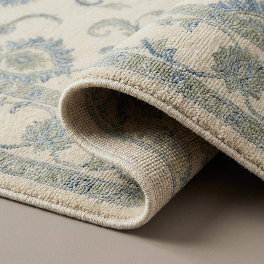 Close up of hand knotted wool rug showing individual knots, natural wool fibers, and soft pile texture