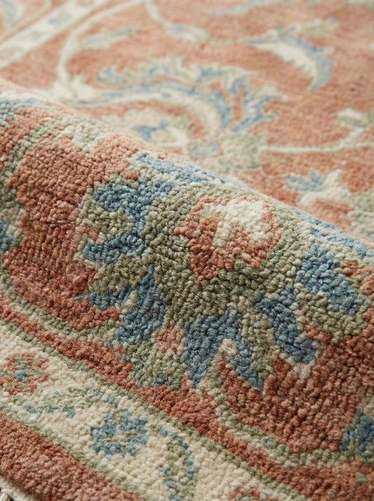 Close up of hand knotted wool rug showing dense knots, natural wool fibers, and low pile texture