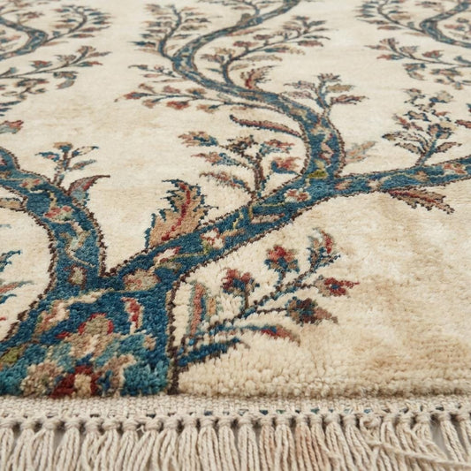 Close-up of dense hand-knotted wool pile showing intricate individual knots and variegated teal yarn texture with a soft, matte finish.