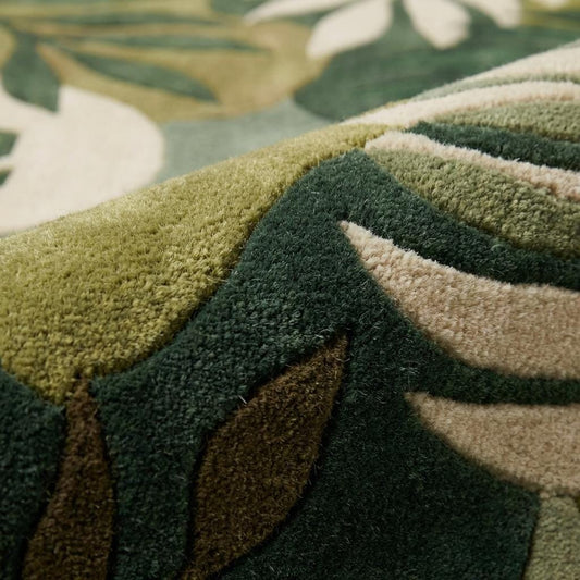Hand tufted botanical leaf wool rug with green tropical design in modern living room