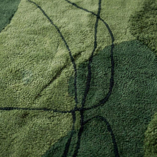 Close up of hand tufted wool rug showing thick pile and carved abstract line detailing