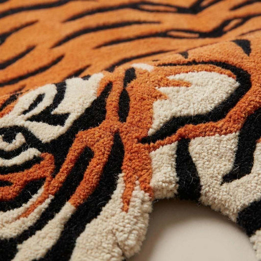 Close up of hand tufted wool rug texture showing dense cut pile fibers forming tiger stripe pattern in orange black and ivory __etsy:7789952528