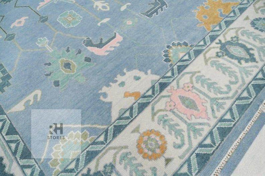 Handmade Oushak wool rug in blue, orange, and white with intricate Turkish knot floral design, perfect for living room decor