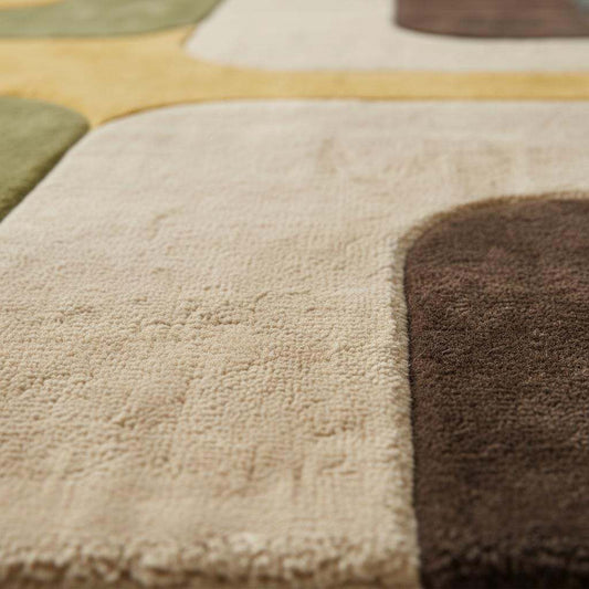 Close-up of hand-tufted cut pile rug showing plush texture, dense fibers, smooth curves, and soft matte finish with visible craftsmanship detail.