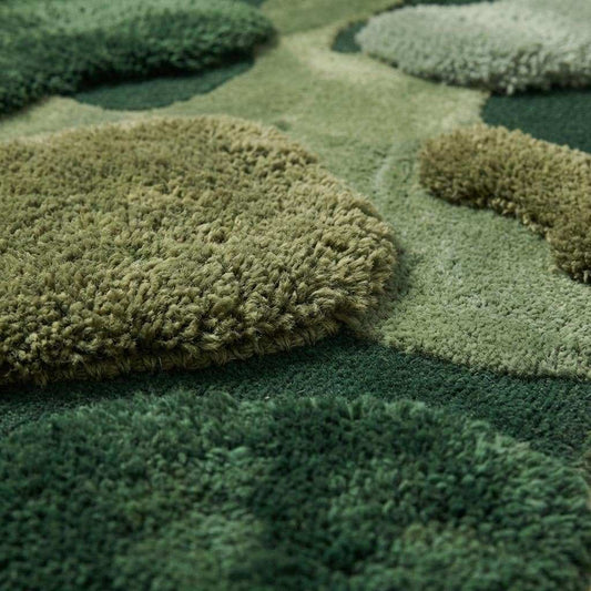 Close up of hand tufted wool moss rug showing high low sculpted pile texture