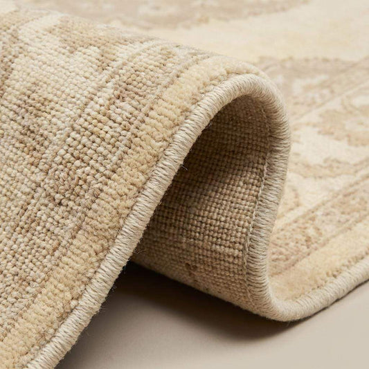 Close up of hand knotted wool rug showing dense pile, individual knots, and natural wool texture