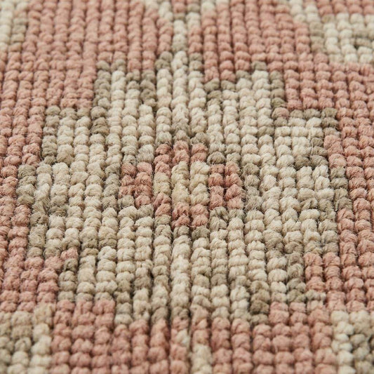 Close up of hand knotted wool rug showing low pile texture, visible knot structure, and natural color variation