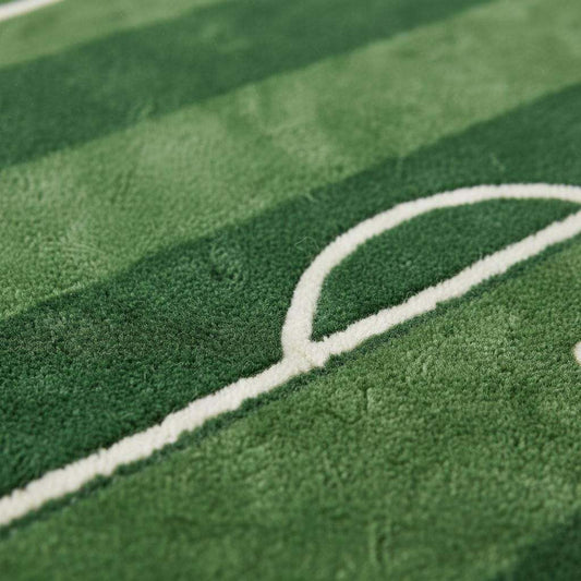 Close-up of plush tufted soccer rug showing soft green pile texture, white field line detailing, and neatly finished edges highlighting craftsmanship and pile height.