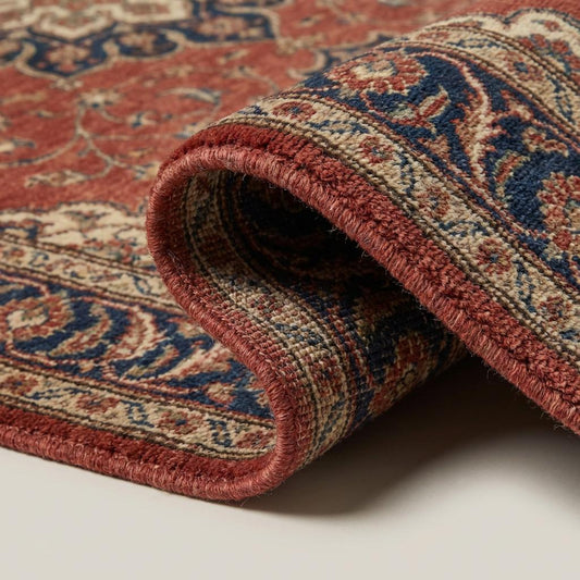 Close-up of hand-knotted wool pile showing dense knot structure and natural fiber variation in rust, cream, and indigo blue yarns.