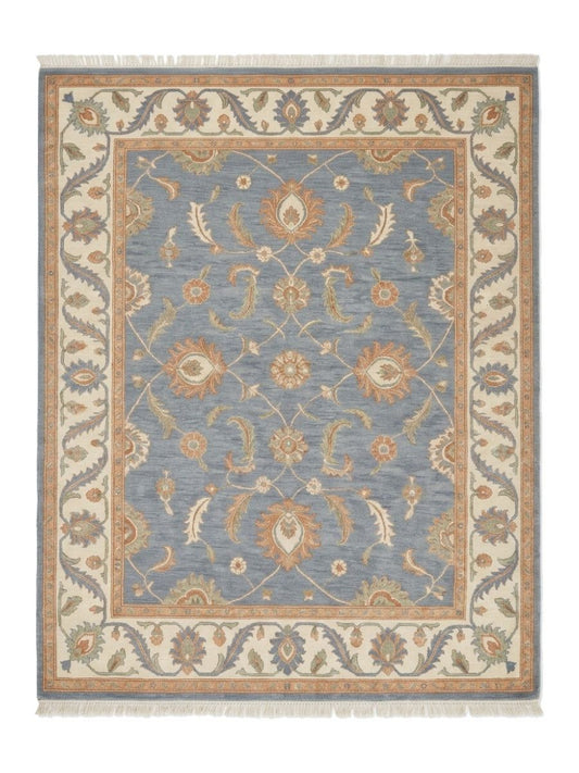 Blue Oushak Rug in slate blue wool with peach and ivory floral motifs, wide ivory border and fringe