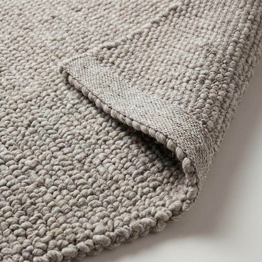 Chunky wool area rug in neutral beige with thick textured weave for cozy minimalist living room decor