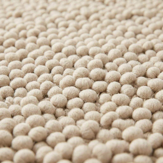 Handwoven chunky wool pebble rug in natural ivory with thick texture for modern nursery and living room interiors