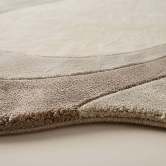 Neutral wavy area rug with sculpted curved abstract design and plush soft texture