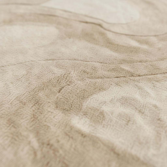 Close-up detail of a handmade tufted rug showing textured wool and stitching