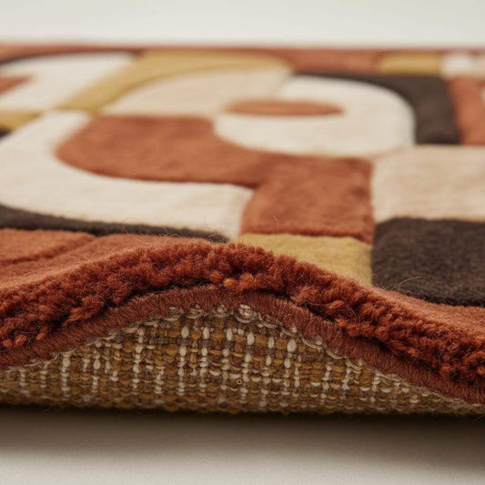 Close up of abstract geometric rug texture showing thick tufted pile, sculpted curves, and plush fibers highlighting craftsmanship and premium material quality.