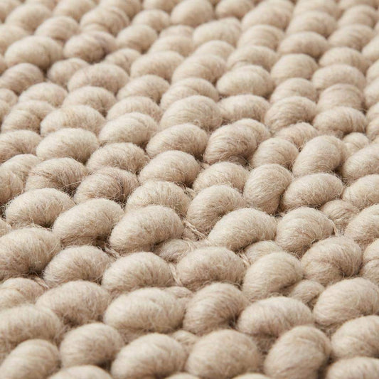 Handmade chunky wool rug with thick knit texture in neutral beige for cozy living room and bedroom decor