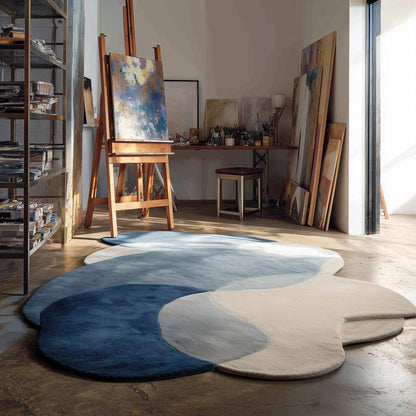 Abstract pebble rug with blue and beige freeform shape and plush cut pile surface
