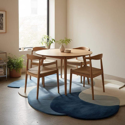 Abstract pebble rug with freeform blue and beige overlapping pebble shapes and plush cut pile surface