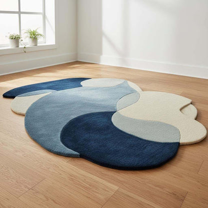 Abstract pebble rug with blue and beige freeform design and plush cut pile surface