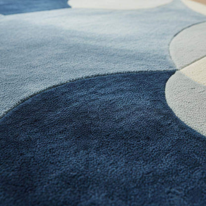 Abstract pebble rug with blue and beige freeform design and plush cut pile surface