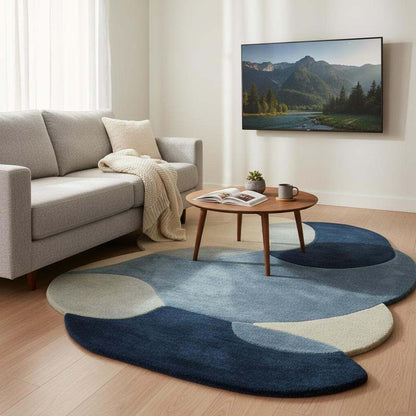 Abstract pebble rug with blue and beige layers, freeform shape, and plush cut pile surface.