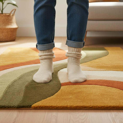 Hand tufted abstract wool rug with retro geometric pattern and organic curves in warm earthy tones