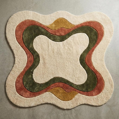 Top-down view of irregular shaped abstract area rug with curved earth tone pattern on cream background, modern boho sculpted carpet design fully visible.