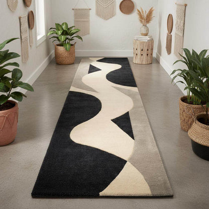 Abstract curved pattern detail of black, ivory, and grey runner rug with smooth flowing lines.