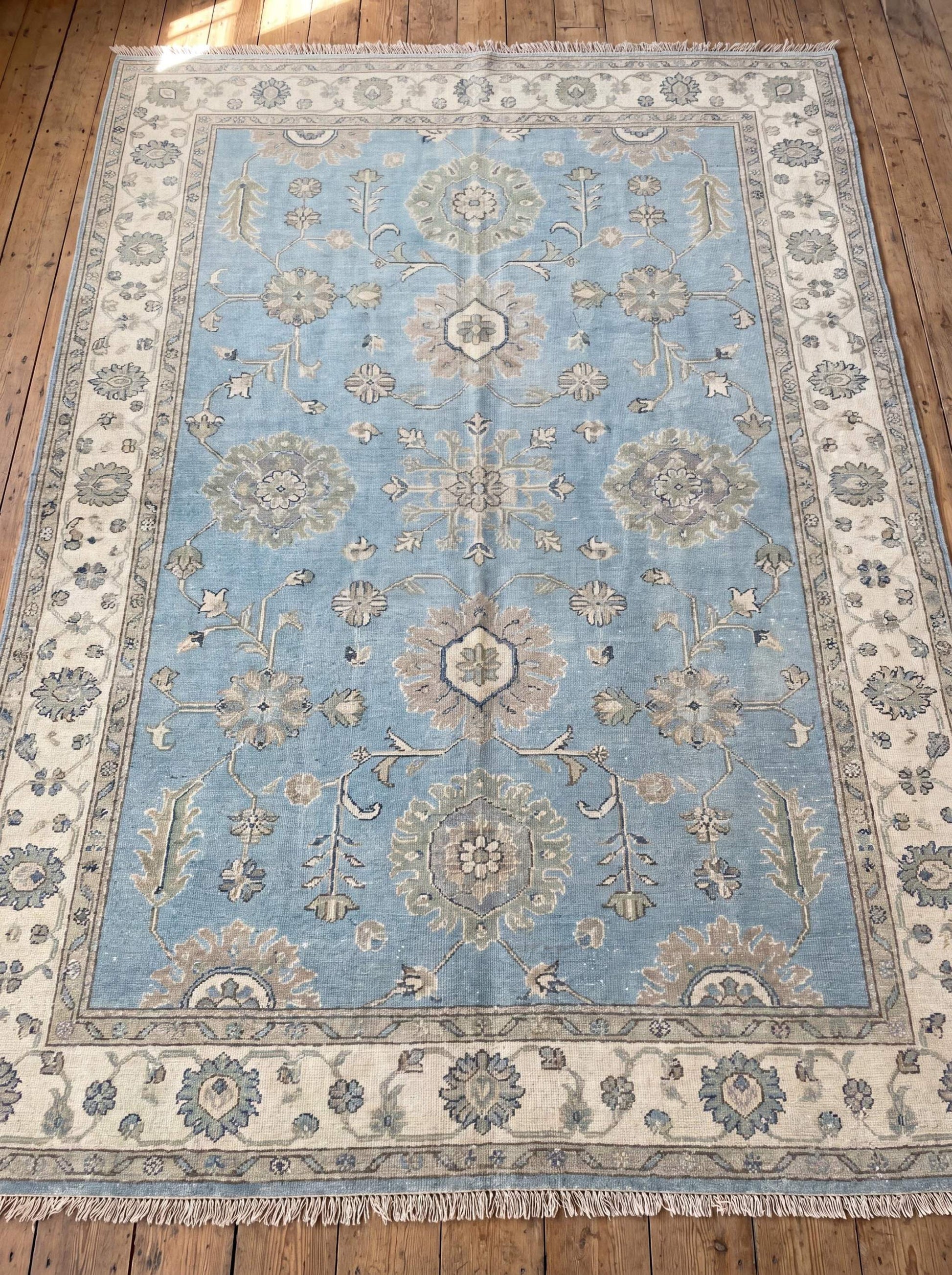 Hand knotted Oushak rug featuring soft blue field, floral motifs, and ivory border for elegant living room décor __etsy:8133057955