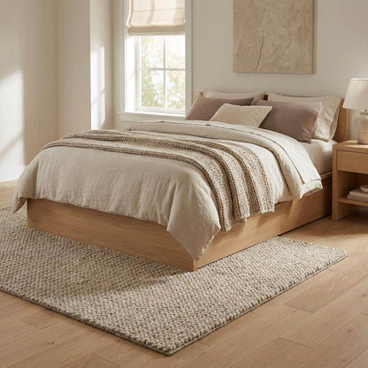 Chunky braided knit rug in neutral beige with thick textured yarn for cozy Nordic interiors