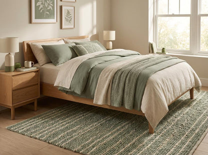 Cozy bedroom or nursery styled with textured sage and cream braided floor rug
