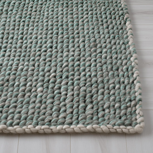 Chunky handknit wool rug in mint green and grey with braided ivory edge for cozy living room decor