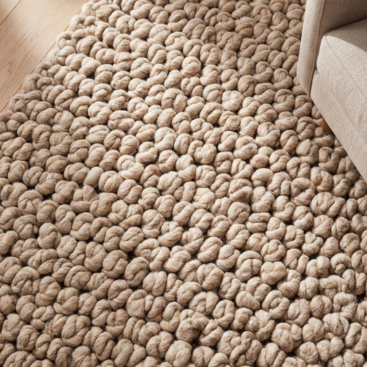 Chunky knit area rug in thick neutral beige with plush handmade cozy texture for living room carpet