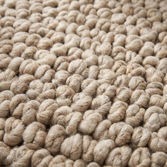 Chunky knit area rug in thick neutral beige with plush handmade texture for cozy living room decor