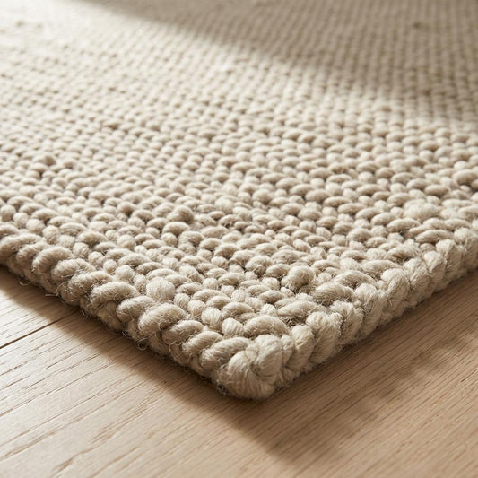 Chunky knit beige braided rug with thick textured wool-look and plush softness for cozy living room decor